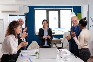 Happy creative business team having meeting in broadroom office victory overjoyed. Multiethnical partners coworkers celebrate successful teamwork result at company briefing photo