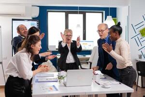 Diverse executive business team clapping in conference room during training. Multiethnical partners coworkers celebrate successful teamwork result at company briefing photo