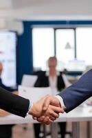 Satisfied businessman company employer wearing suit handshake in conference room , workplace. Man hr manager employ successful candidate shake hand at business meeting, placement concept photo