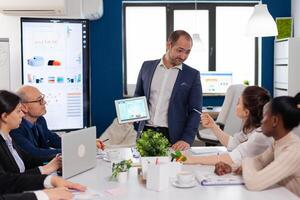 Employee asking executive questions during presentation briefing conference room presentation. Project leader discussing with teamworkers in broadroom, analysing charts, graphs, financial evolution of company. photo