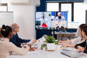 Headshot screen application view of remote multiracial employees talking on call brainstorm together. Business people talking to webcam, do online conference participate internet brainstorming, distance office discussion. photo