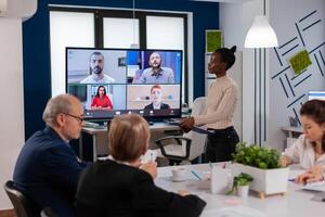 African woman discussing with remote managers on call presenting new partners on webcam. Business people talking to webcam, do online conference participate internet brainstorming, distance office discussion. photo