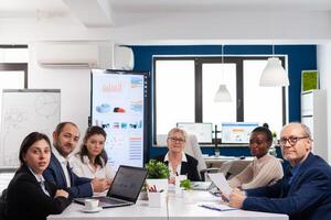 Pov of diverse team sitting in conference room during virtual meeting, discussing online with business partners. Internet conference call technology talk with investors, corporate brainstorming via web. photo