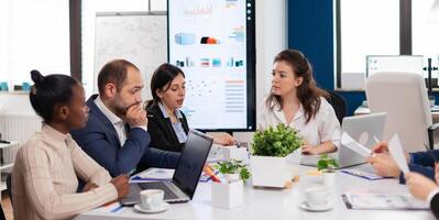 Woman company leader talking at diverse group board meeting, multiethnic team. Businesswoman discussing ideas with colleagues about financial strategy for new start up company. photo