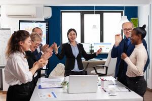 Motivated happy diverse business team people clapping celebrating success at corporate meeting. Multiethnical partners coworkers celebrate successful teamwork result at company briefing photo