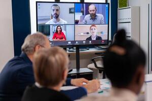 Headshot screen application view of remote multiracial employees talking on call brainstorm together. Business people talking to webcam, do online conference participate internet brainstorming, distance office discussion. photo