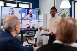 African woman discussing with remote managers on call presenting new partners on webcam. Business people talking to webcam, do online conference participate internet brainstorming, distance office discussion. photo