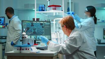 Medical research scientist typing codes on pc in biological applied science modern equipped laboratory overwork. Lab engineers conducting experiment for vaccine development against covid19 virus photo