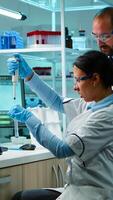 Scientist woman pipetting liquid to test tube working in equipped lab late at night. Chemists examining virus evolution using high tech for scientific analysis of treatment development against covid19 photo