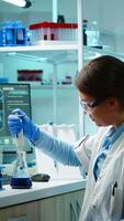 Scientist woman pipetting liquid to test tube late at night in modern equipped lab. Team examining virus evolution using high tech for scientific analysis of treatment development against covid19 photo