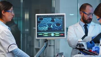 Group of researchers checking virus evolution conducting vaccine development with help of high tech, analysing results and planning next steps working late at night in modern equipped laboratory photo