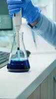 Close up of scientis testing liquid sample late at night using micropipette for medical treatment in laboratory. Team examining virus evolution using high tech for vaccine development against covid19 photo