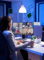 Start up manager working overtime late at night from business office talking online via web internet conference call with partners. Freelacner on videoconference corporate meeting using videocall chat photo