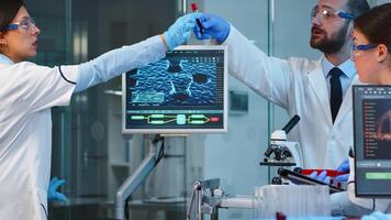 Team of scientists doing biological researches under microscope, lab technician writing data in computer in modern equipped laboratory Group of doctors examining virus evolution using high tech. photo