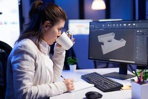 Software engineer working at digital cad project late at night in office company. Woman entrepreneur looking at technical construction before deadline using modern technology network photo