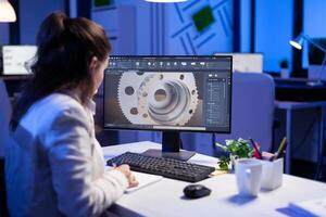 Woman engineer working on new digital prototype using professional construction equipment late at night at office company. Entrepreneur looking at technical architecture before deadline photo