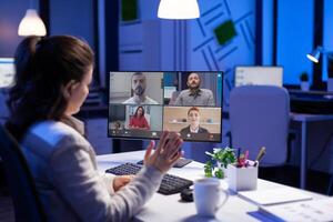 Manager during online conference with corporate team after midnight using pc in start up business office. Videoconference internet meeting with technology network wireless discussing on call late at night photo
