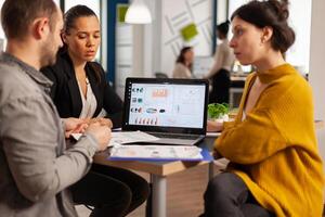 Business people talking with team leader using clipboard with documents pointing on it, presenting startup financial ideas to manager, brainstorming project management strategy in company office photo