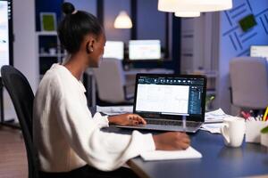 African engineer constructor designer architect analysing new bluilding plan in CAD program working in business office. Industrial woman employee studying prototype idea showing cad software on device display. photo