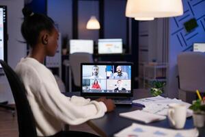 African american businesswoman having online business meeting with remote partners discussing company strategy during videocall conference. Teleconference call on laptop screen in office photo