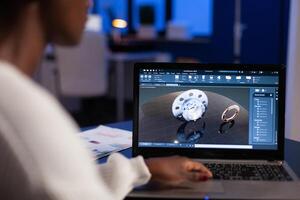African american engineer developing engineering gear design working at industrial mechanical prototype late at night in startup company office. Project designer using industry construction software photo