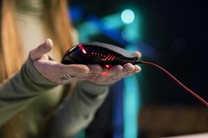 Media star filming review of newly released gaming led lights mouse, close up shot. Woman giving viewers feedback about computer peripheral performance, recording in home studio photo