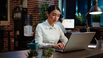 Zoom in on company accountant typing down financial notes on laptop and analyzing sales report to plan business development. Office employee using computer to do project research photo
