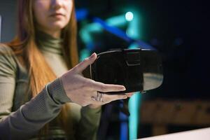 Gen Z tech content creator filming technology review of newly released VR goggles, unboxing them and presenting specifications to audience. Influencer showing virtual reality device to fans, close up photo