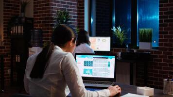 Worker looks over statistical data financial graphs on laptop screen, researching key data for company project. Businesswoman analyzing stock market figures and charts on electronic device, camera A photo