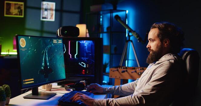 Man in RGB lit studio streaming multiplayer game, chatting with audience while defeating enemies, zoom out shot. Pro gamer using professional equipment to broadcast videogame gameplay to fans photo