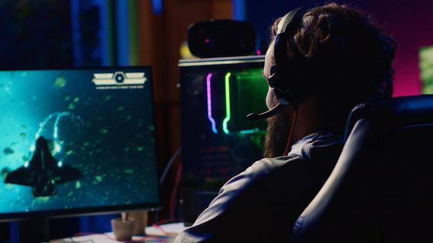 Man playing high FPS singleplayer game with spaceship shooting laser streams at asteroid. Gamer using crosshair overlay to hit targets and win mission Scifi game with ray tracing graphics photo