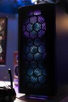 RGB lights illuminated fans on gaming computer capable of playing latest games, close up shot, empty apartment. Focus of components on powerful desktop PC in home living room photo