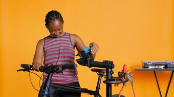Engineer setting up bike repair stand, using it to adjust derailleur and cables, fixing broken wheels, studio background. Professional assembling workstand to maintain bicycle at eye level, camera B photo