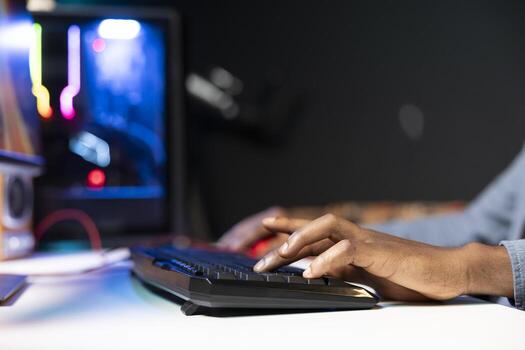 Keyboard used by gamer competing in online multiplayer videogame at home, close up shot. Focus on computer peripheral utilized by man playing on gaming PC in neon illuminated apartment photo