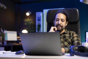 Freelancer working from the comfort of their home, surrounded by a contemporary and neat living room setup, using a laptop to browse the web and communicate, exemplifying the modern online lifestyle. photo