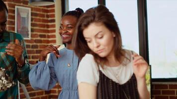 Close up shot of merry friends dancing at house party while drinking wine glasses, enjoying celebration. Multiethnic group of people having fun, doing skillful dance moves to music in apartment photo