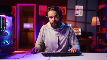 Focused gamer plays intense videogame tournament online during stream with audience, trying to defeat opponent. Player participating in esports competition during livestream, fighting enemies photo