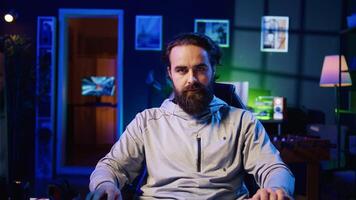 Professional gamer engaging in online competitive multiplayer match using cutting edge gaming setup. Zoom in close up on man at home captivating spectators during live broadcast, playing videogames photo