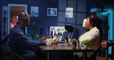 Show host recording podcast with guest, using analog mixer and professional mic in studio. Zoom out shot of man setting up audio device for live broadcast with woman, ensuring flawless sound quality photo