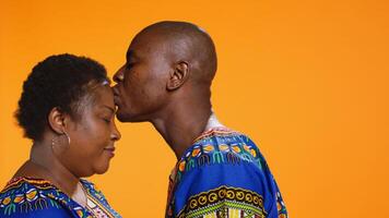Caring man giving a kiss on his girlfriend forehead, presenting his love and affection for her. Romantic boyfriend kissing his partner, showing sincere deep feelings on camera. Close up. photo