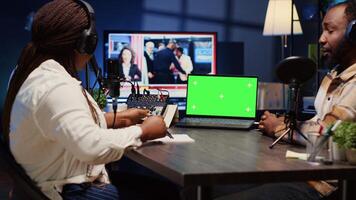 Isolated screen laptop on desk next to presenter on podcast chatting with guest during marathon stream for humanitarian cause. Chroma key notebook used by host to check gathered donations from fans photo