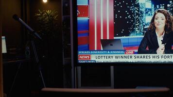 TV left open at night on streaming service channel with news reporter covering different subjects. Close up shot of smart TV in empty dimly lit apartment showing journalist talk about reportages photo