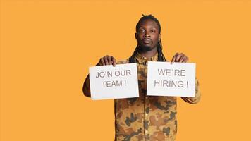 HR manager handling recruitment to fill job vacancy, showing papers for hiring and job offers advertisement. African american recruiter looking for workforce, search for people. photo