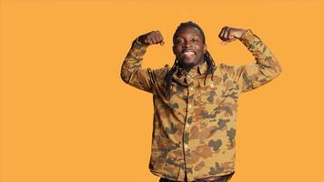 Strong person flexing his muscles on camera and showing his toned physique, athletic man with huge biceps. Powerful african american guy feeling confident after going to the gym. photo