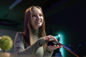 Smiling gen Z influencer presenting wired gaming mouse from brand sponsoring , urging viewers to buy it. Upbeat internet star excited to promote computer peripherals to audience photo