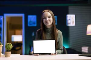 Smiling girl presenting mockup tablet in entry level low budget price range. Upbeat gen Z content creator reviewing isolated screen digital device in front of internet fanbase photo