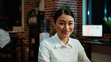 Zoom in on joyful asian employee writing important emails at computer desk, finalizing deal with business partners. Portrait close up shot of happy employee typing on laptop, camera A photo