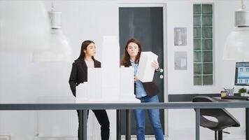 Experts measure models printed in 3D to determine proportions while working on unicorn business expansion goals. Women builders develop architectural blueprints using scale dimensions. photo