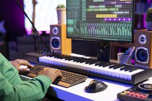 Sound designer operating on a professional editing software on pc, mixing and mastering his old track records in home studio. Producer uses stereo equipment and amplifier. Close up. photo