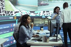 Indian woman employee offers order tracking updates in control center, managing complains from customers. Dispatch operator ensures faster cargo shipping with satellite navigation. photo